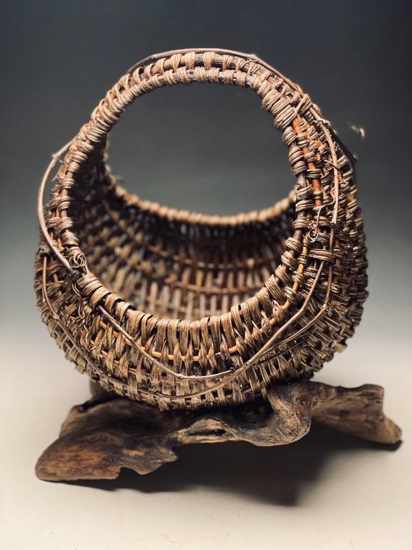 sculptural art basket by matt tommey using kudzu, grapevines, driftwood and willow branches. Infused with encaustic wax and black walnut dye.