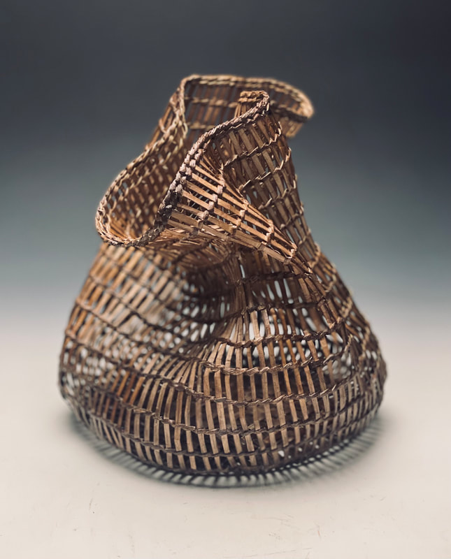Freeform open weave basket by matt tommey made from kudzu and poplar bark, infused with encaustic wax and black walnut dye.