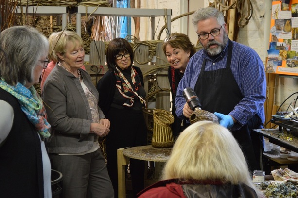 Matt Tommey of Asheville, North Carolina's River Arts District shows a group how he covers his handcrafted art basket sculptures with encaustic wax.