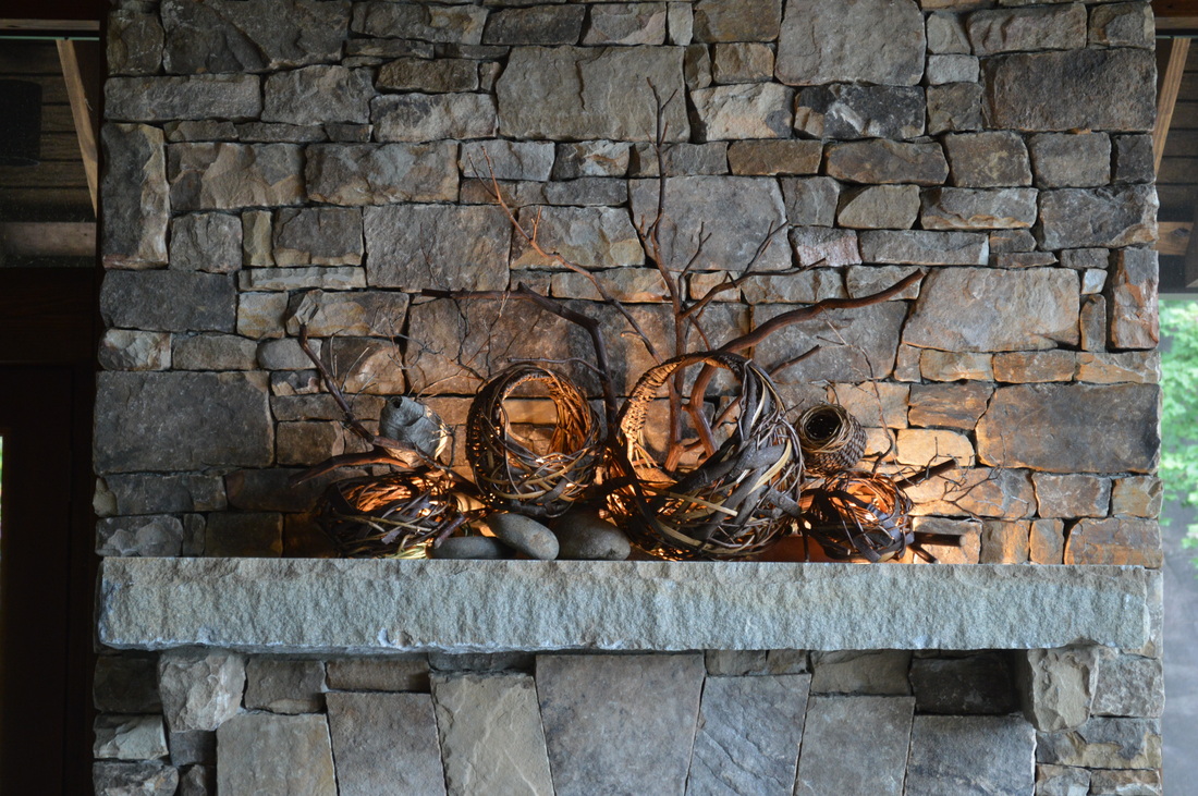 3 Baskets With Candlelit Branches Behind Them As Fireplace Mantel Art
